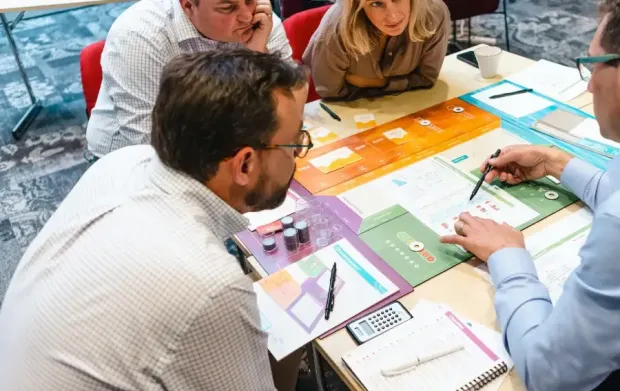 People in a room playing CELEMI Enterprise™ business simulation