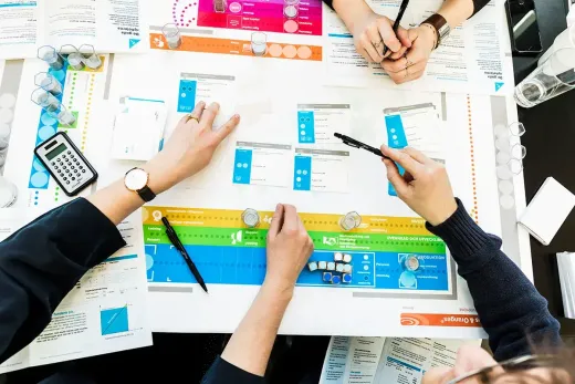 Top view of people playing CELEMI Apples and Oranges™ business simulation